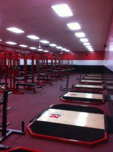 red gym floor with weight training stands